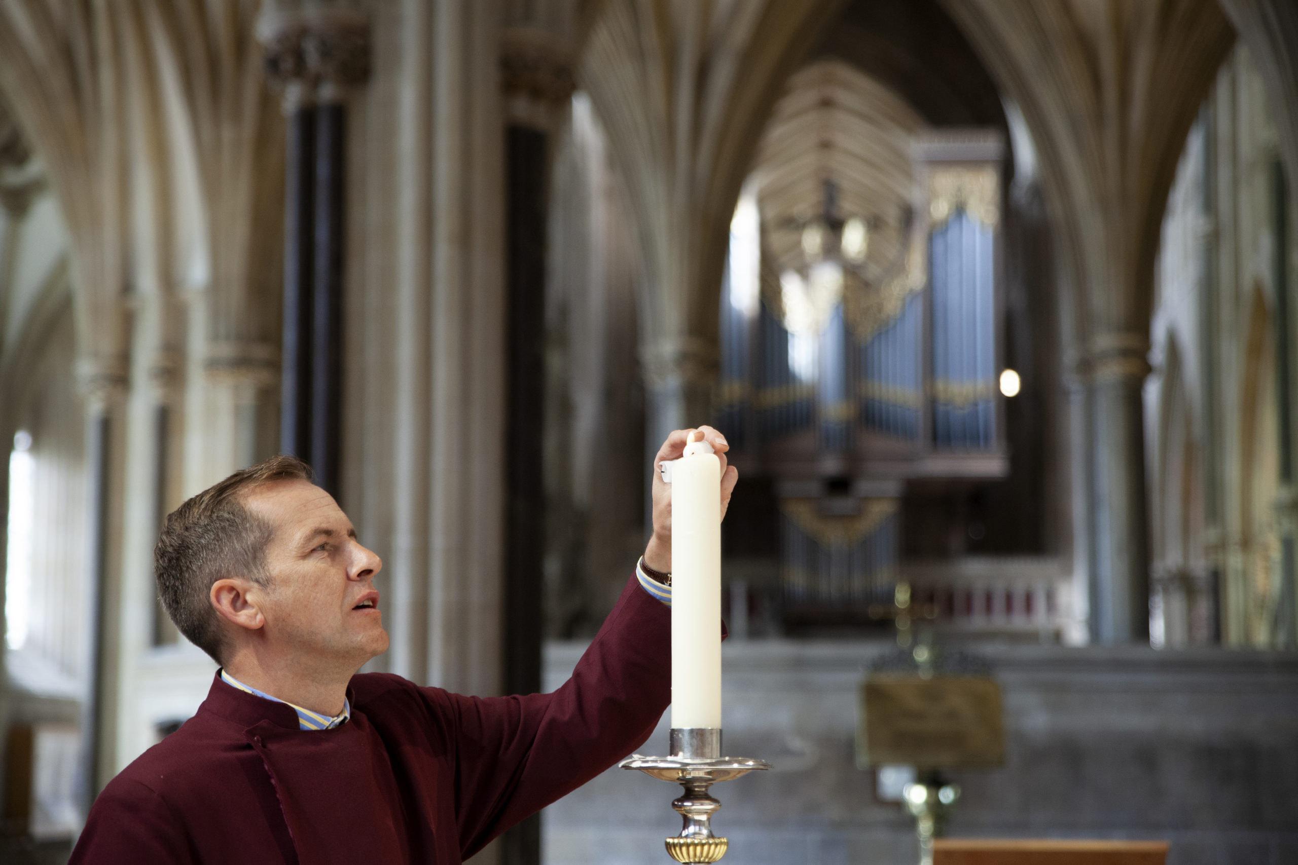 a virger lighting a candle
